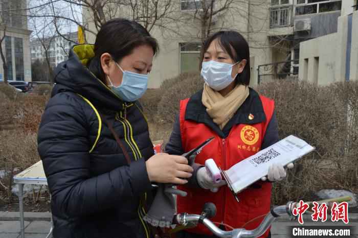 李悦为社区居民测体温,帮助居民登记扫码信息 张桂芹 摄  河北承德一社区女书记抗“疫”38天未休息:“吃点苦受点累不算啥!”