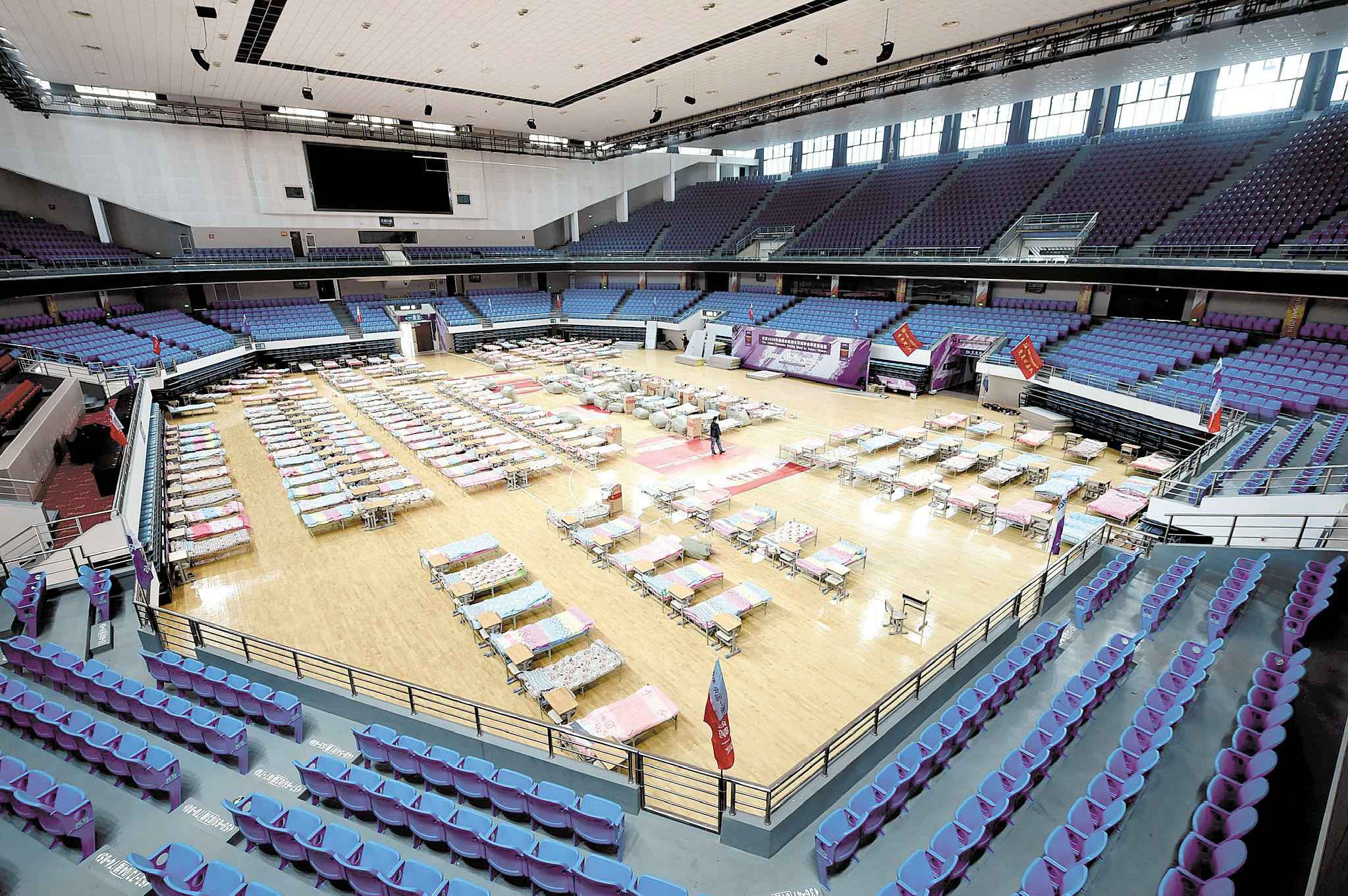 连夜搭建的洪山体育馆“方舱医院”。 (湖北日报全媒记者 李溪 摄)  先期提供万余张床位 “方舱医院”星夜搭建