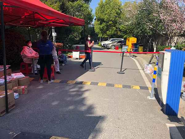 H社区某小区进门处拉起了红色警戒线,地上堆着居民的快递和生活用品。澎湃新闻记者 钟笑玫 图  武汉“零新增”前后:封城两月,不是终点