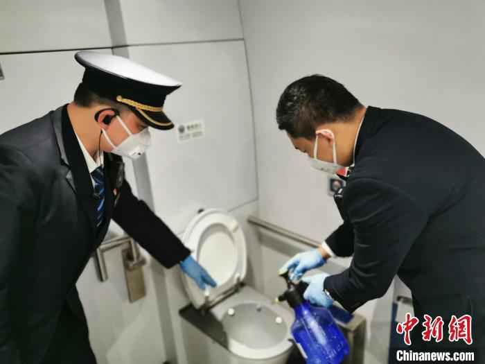 黄涛指导同事为卫生间消毒。沈铁 供图  最美“逆行”列车长与列车里飞出的“战疫”之歌