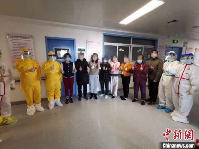 图为,患者与医护人员合影。山东大学齐鲁医院供图  山东支援湖北医疗队贡献战“疫”齐鲁智慧