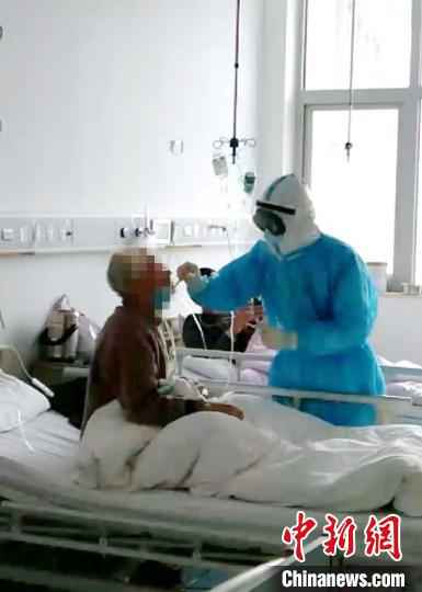 图为,医护人员在给患者取咽拭子,进行诊疗。山东大学齐鲁医院供图  山东支援湖北医疗队贡献战“疫”齐鲁智慧