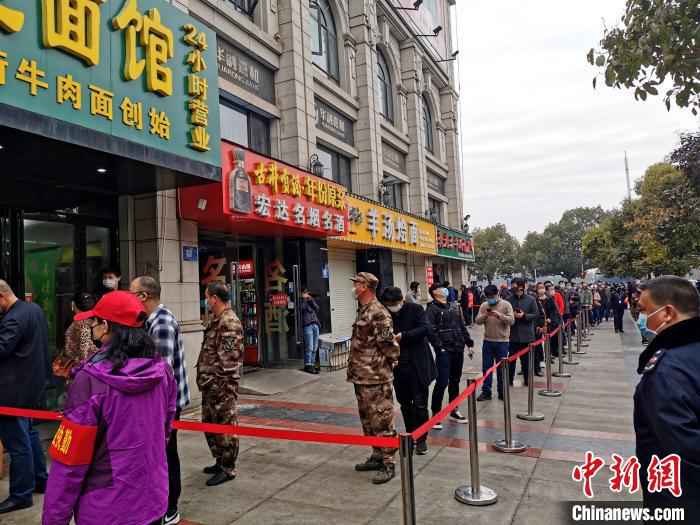 襄阳一桥头下,居民排队购买牛肉面 胡传林 摄  襄阳战“疫”记:一碗牛肉面再现古城“烟火气”